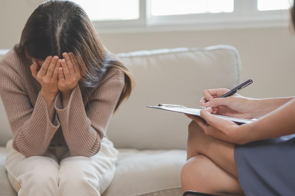 A woman cries at her desk as another woman comforts her. A lawyer can help you understand the signs of sexual abuse in a relationship and how to get help.